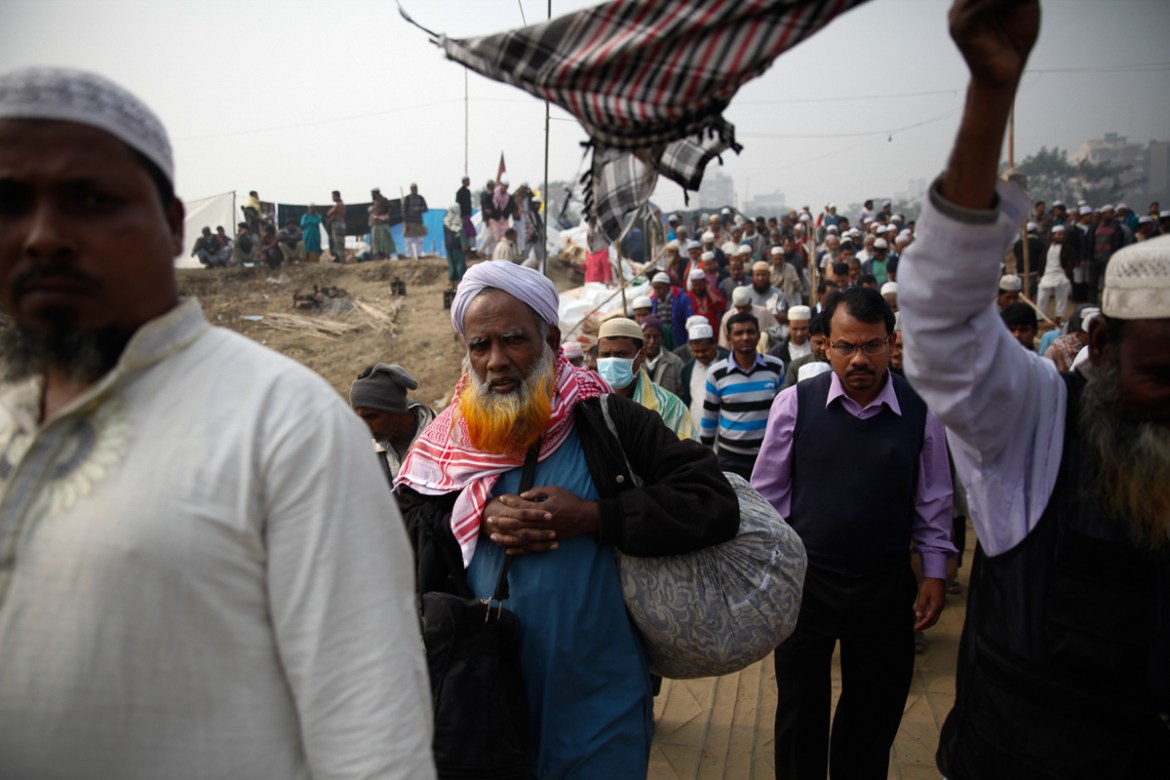 Muslim devotees carry their belongings as they arrive at the Biswa Ijtema Turag in Tongi. [Mahmud Hossain Opu/Al Jazeera]