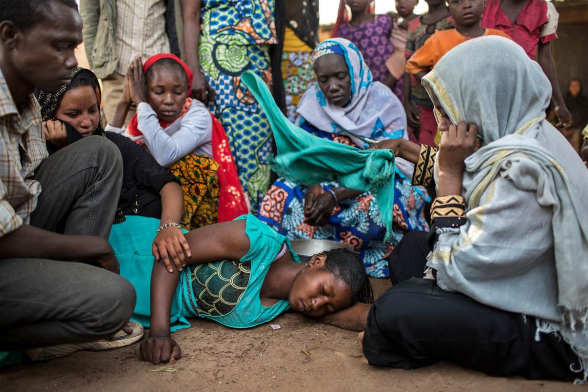 People comfort the sister of a Muslim man who was kidnapped, held for ransom and then murdered when his family could not pay the amount demanded by kidnappers in Paoua town, Central African Republic,