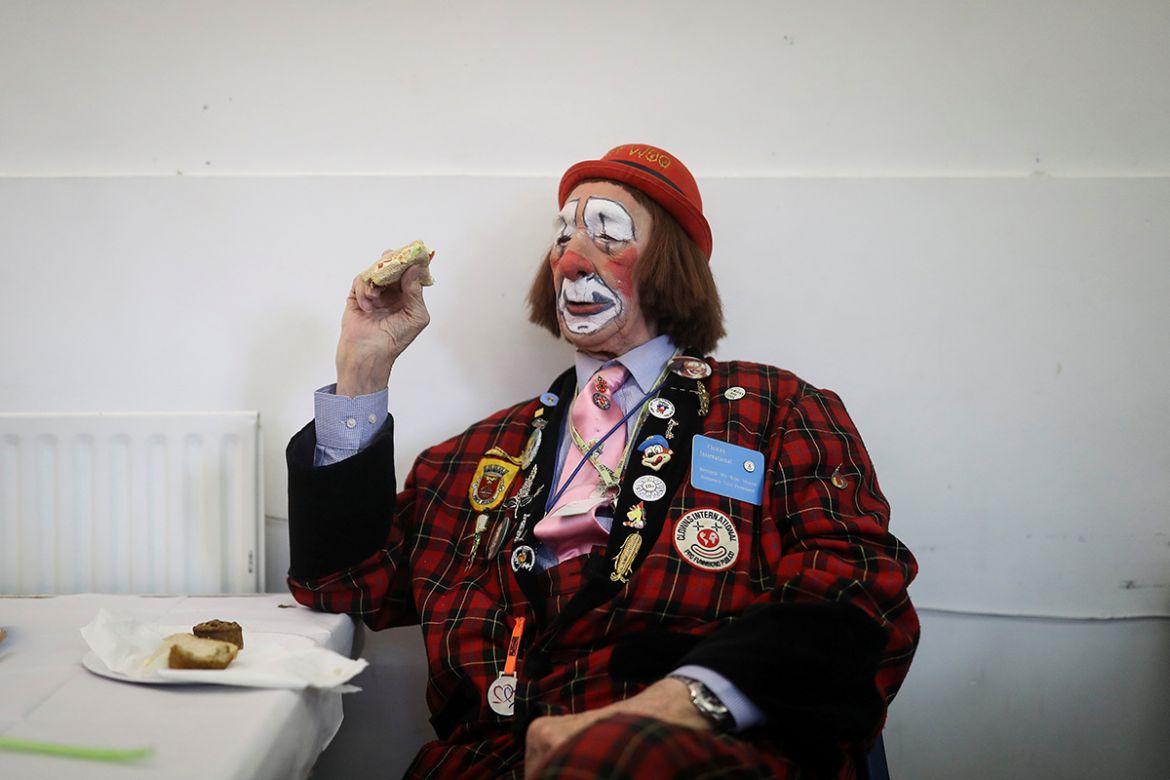 A clown stops to eat a sandwich before attending an annual service of remembrance in honour of British clown Joseph Grimaldi at All Saints Church in Haggerston in London, Britain February 4, 2018. REU