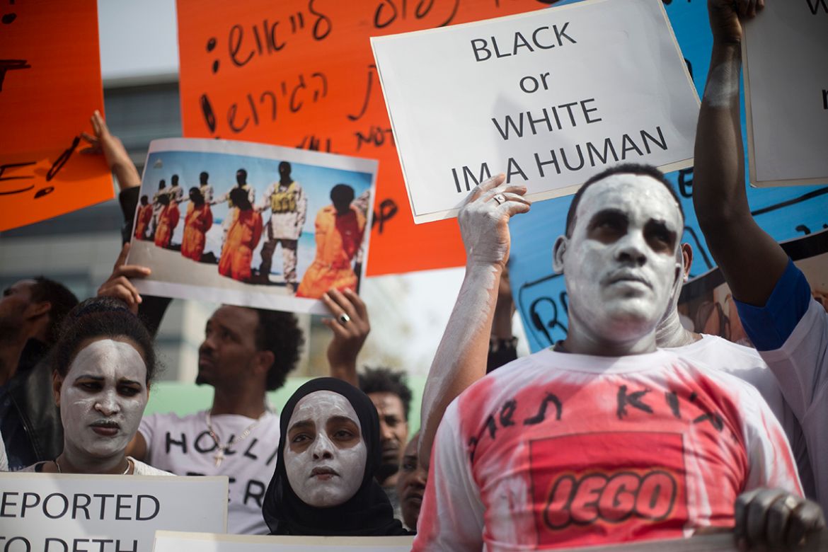 African migrants hold signs during a protest in front of Rwanda embassy in Herzeliya, Wednesday, Feb. 7, 2018. African asylum seekers are protesting an Israeli plan to deport them.Israel says thousand