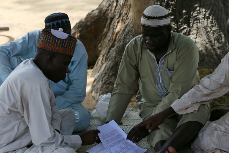 Parents of missing school girls check name lists in Dapchi in the northeastern state of Yobe, after an attack on the village by Boko Haram