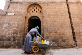 33 year old Mohammed Ali unloads jerry cans from his wheelbarrow in the Old City of Sana''a which will supply his family with safe water. He fled with ten family members from Yemen’s northern province