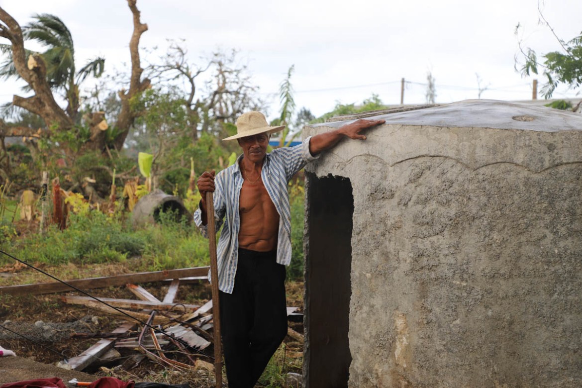 Isi Vaea stands by the water tank he and his family sheltered in during Tropical Cyclone Gita. Their house on the Tongan island of Eua has been completely destroyed.