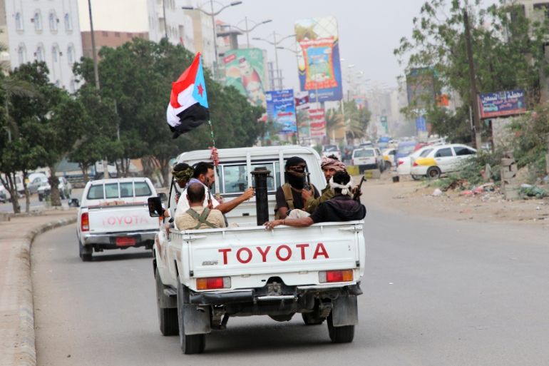 Southern Yemeni separatist fighters ride on the back of a patrol truck in the port city of Aden