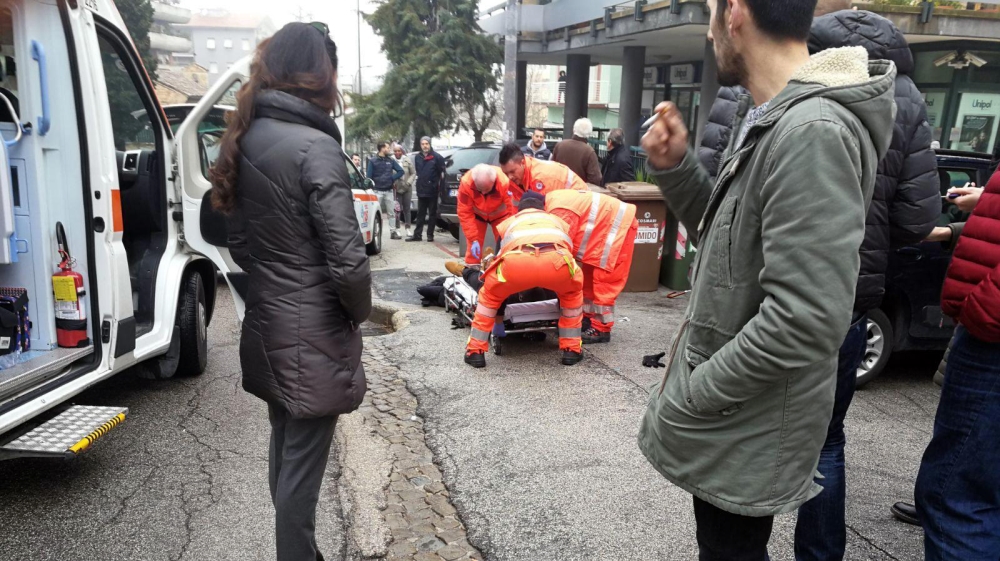 Paramedics treat an injured person that was shot in Macerate [EPA]