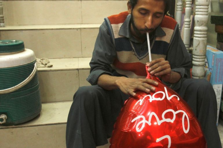 A man inflates a heart shaped balloon ahead of Valentine''s day in Peshawar