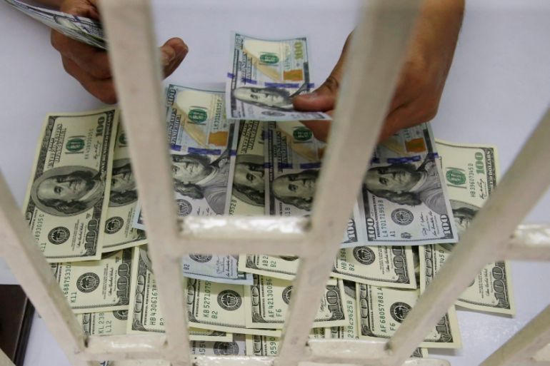 A worker counts U.S. dollar bills inside a money changer in Metro Manila