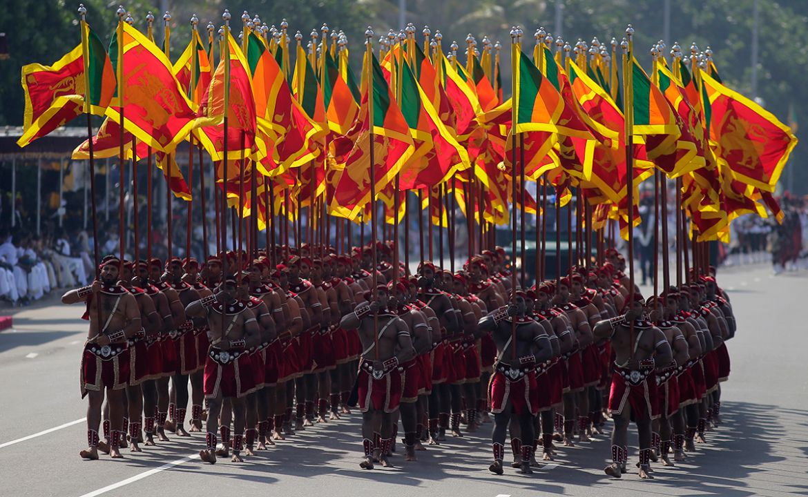Sri Lankan army soldiers, dressed in traditional costumes, march with national flags during the 70th Independence Day parade, marking the country''s independence from British colonial rule in 1948 in C