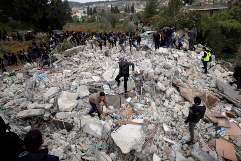 People stand on the rubble of the house of Palestinian gunman Ahmed Jarrar following an Israeli raid, in the West Bank city of Jenin