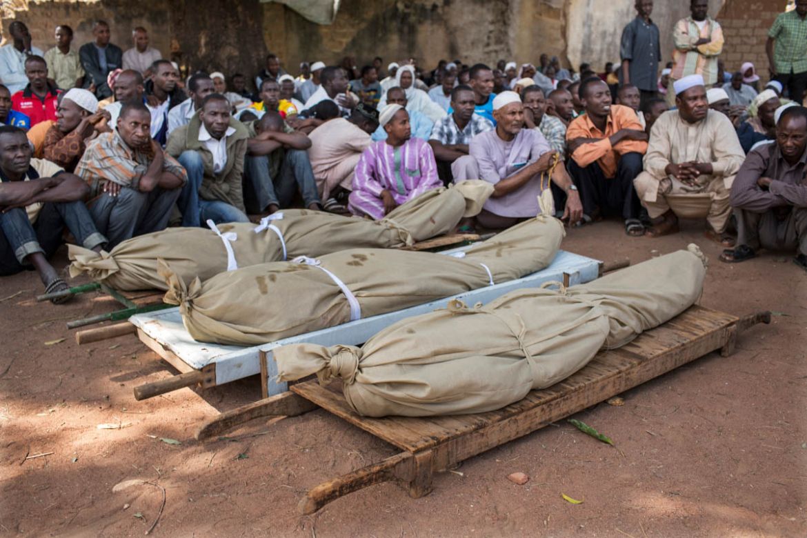 Men gather around the bodies of three young Muslim men who were kidnapped, held for ransom and then murdered when their families could not pay the amount demanded by kidnappers in Paoua town, Central