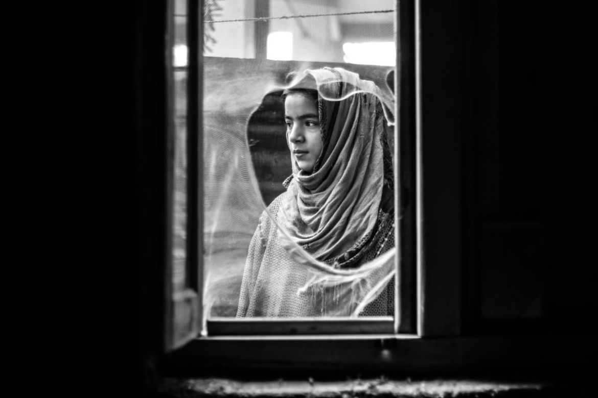Ten-year-old Insha looking outside window of her house at village Dialgam in Anantnag district, about 55 km south of Srinagar city, the capital of Indian-controlled Kashmir. Insha''s father was killed