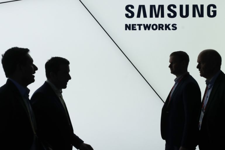 Visitors pass in front of the Samsung networks booth at the Mobile World Congress in Barcelona