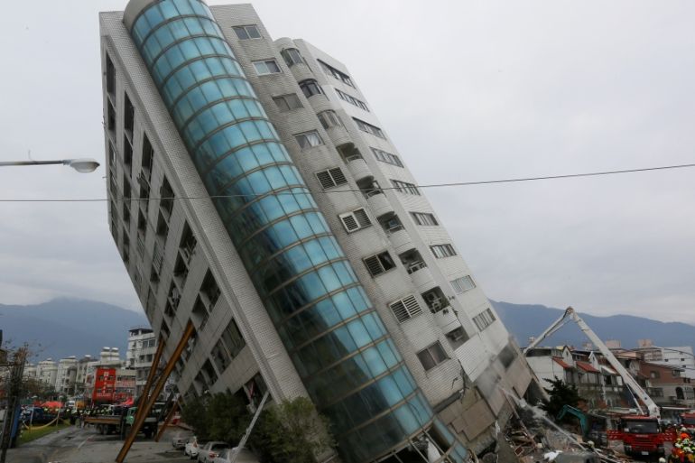 Rescue workers are seen by a damaged building after an earthquake hit Hualien
