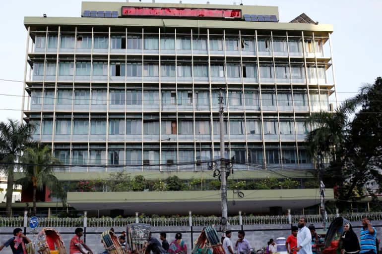 Commuters walk in front of the Bangladesh central bank building in Dhaka