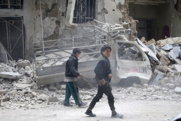 Children are inspect damages on a street in the besieged town of Douma, eastern Ghouta, in Damascus