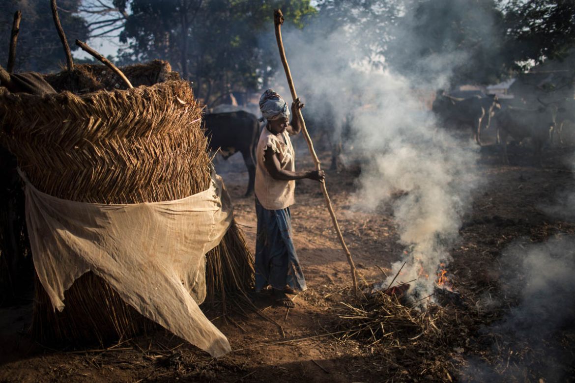 A displaced woman tends to a fire near a host family’s cattle in Paoua, Central African Republic, January 31, 2018.
