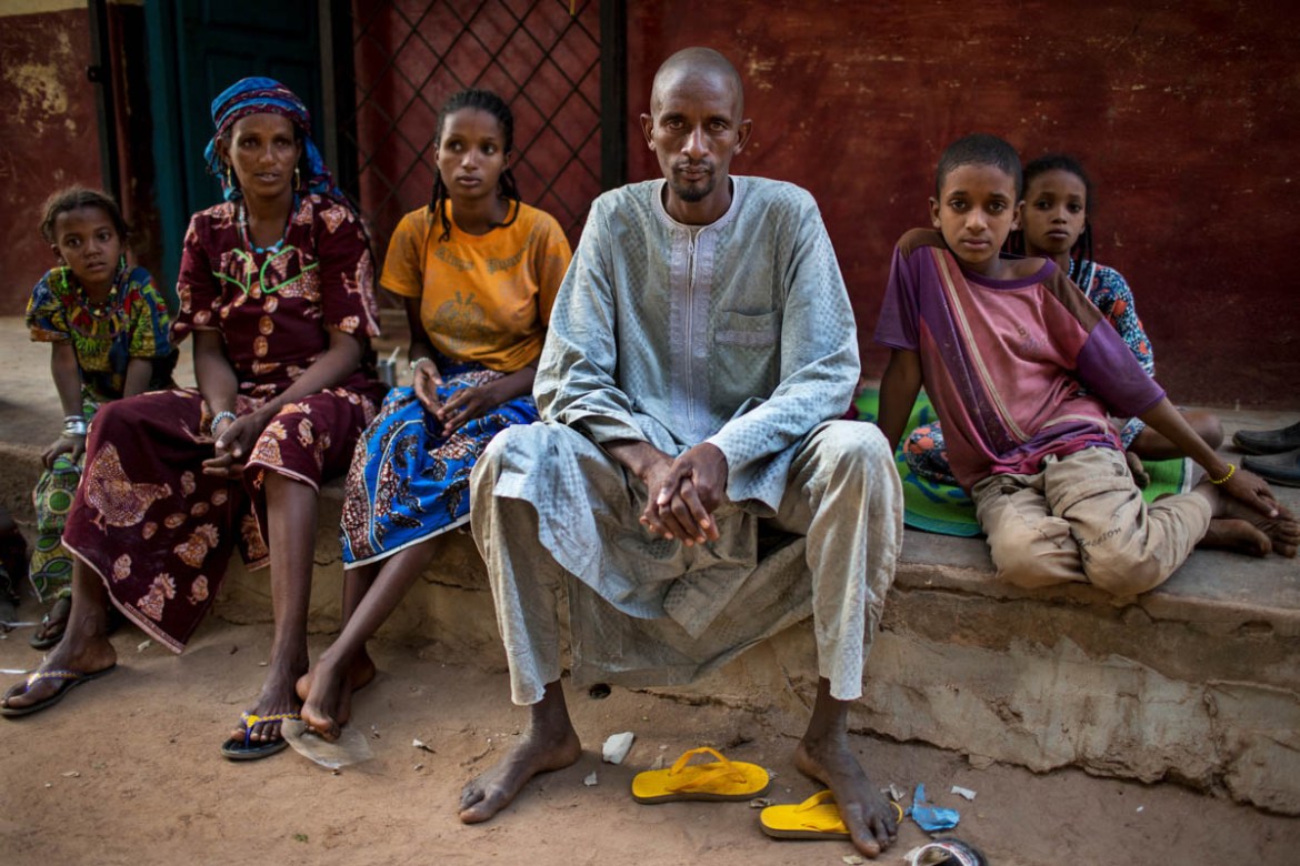 Mepala Bakary (center) sits with several of his family members at the abandoned house where they have taken shelter outside the MINUSCA base in Paoua town, Central African Republic, January 29, 2018.