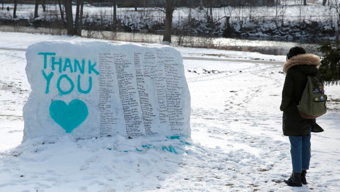 Michigan State University student Isabella Ndlebe stops to look at "The Rock" painted with the names of assault victims of Larry Nassar, a former team USA Gymnastics doctor who pleaded guilty in Novem