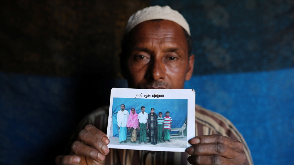 Abdu Shakur, whose son Rashid Ahmed was among 10 Rohingya men killed by Myanmar security forces and Buddhist villagers on September 2, 2017, holds a family picture at Kutupalong camp in Cox's Bazar, Bangladesh, January 19 [Mohammad Ponir Hossain/Reuters]