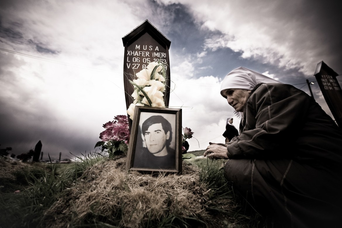 A Kosovar woman prays at the grave of her son was killed during the war. The son''s body was found in a mass grave not far from Krusa e Madhe