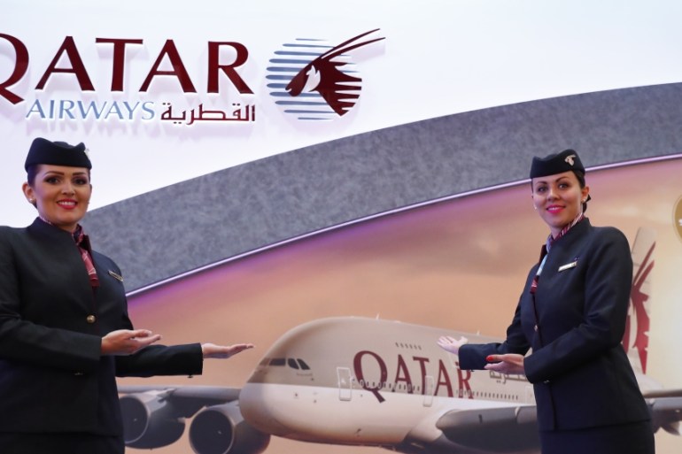 Exhibitors pose at the Qatar Airways booth at the International Tourism Trade Fair ITB in Berlin