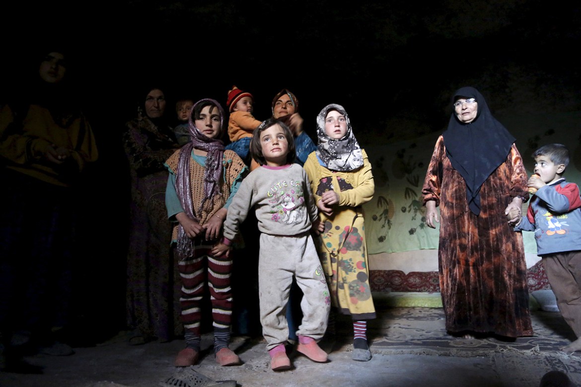 Internally displaced Syrians stand inside their makeshift shelter that is an underground cave in Om al-Seer, southern Idlib countryside, Syria December 26, 2015. REUTERS/Khalil Ashawi TPX IMAGES OF TH