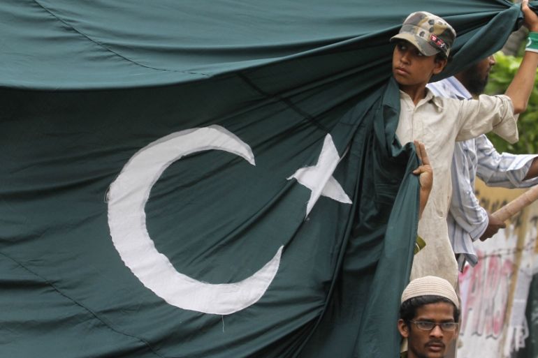 A supporter of the Jamaat-ud-Dawa Islamic organization holds Pakistan''s national flag during an anti-India protest in Karachi