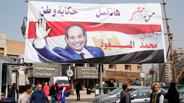 People walk by a poster of Egypt''s President Abdel Fattah al-Sisi for the upcoming presidential election, in Cairo