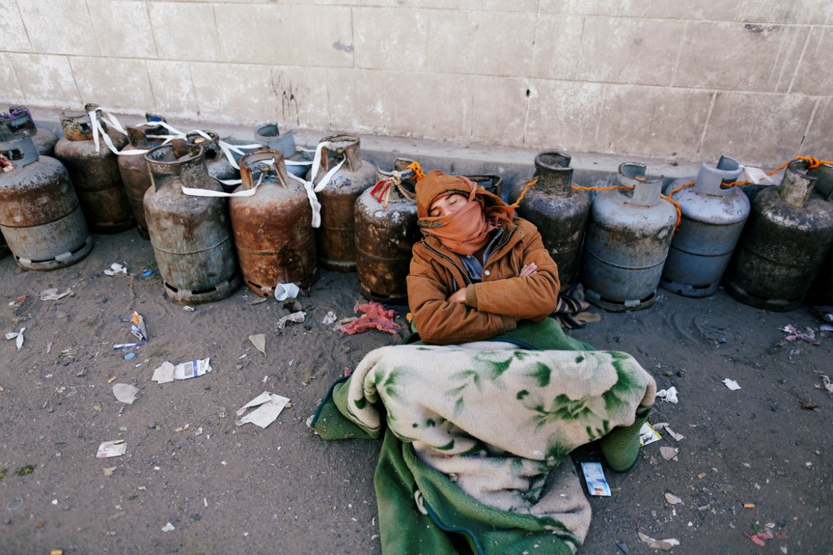 A man sleeps next to a queue of cooking gas cylinders outside a gas filling station amid a scarcity in cooking gas supplies in Sanaa, Yemen March 4, 2018 . REUTERS/Khaled Abdullah TPX IMAGES OF THE DA