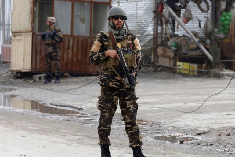 Member of the Afghan security force keeps watch at the site of a suicide bomb attack in Kabul