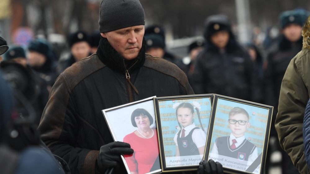 A man shows portraits of family members he lost in the March 25 fire in Kemerovo, Russia on March 27 [Getty Images]
