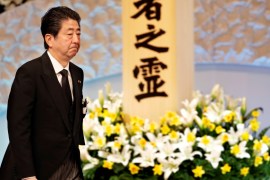 Japan''s PM Abe walks after offer in front of an altar for the victims of the March 11, 2011 earthquake and tsunami at the seventh national memorial service in Tokyo