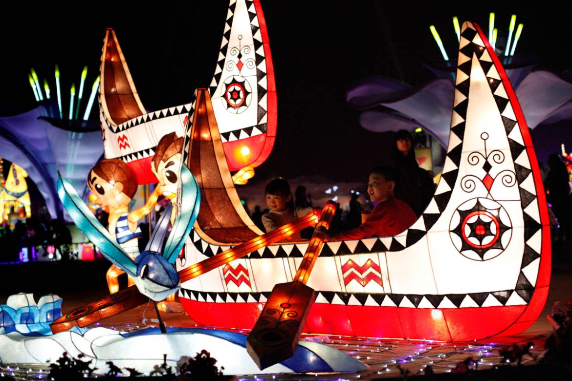 Children sit and play in one lantern shaped as “Tatala,” the boat made by the Tao, an indigenous group lives on the Taiwanese island of Lanyu in Pacific Ocean. This year’s Taiwan Lantern Festival feat