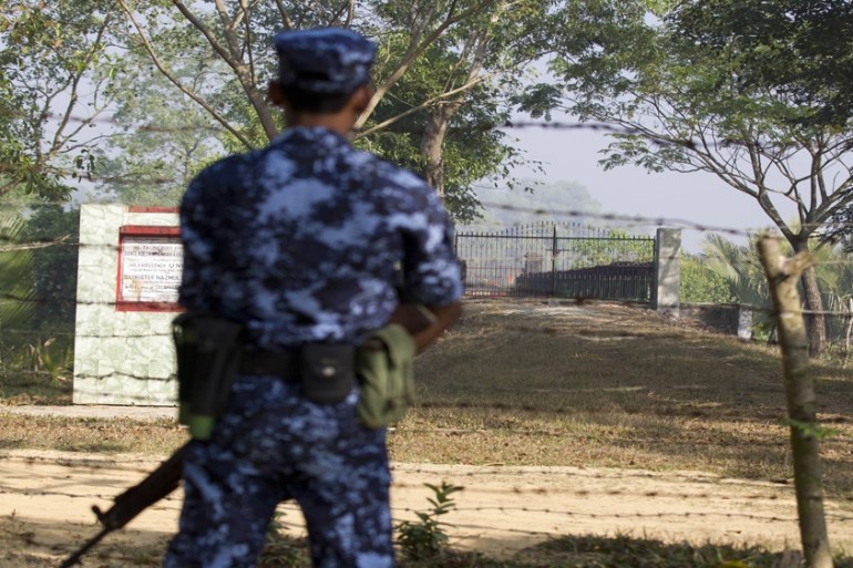 A Myanmar police guard stands guard at the border near the newly-built repatriation camps prepared for Rohingya refugees expected to be returning from Bangladesh, Wednesday, Jan. 24, 2018