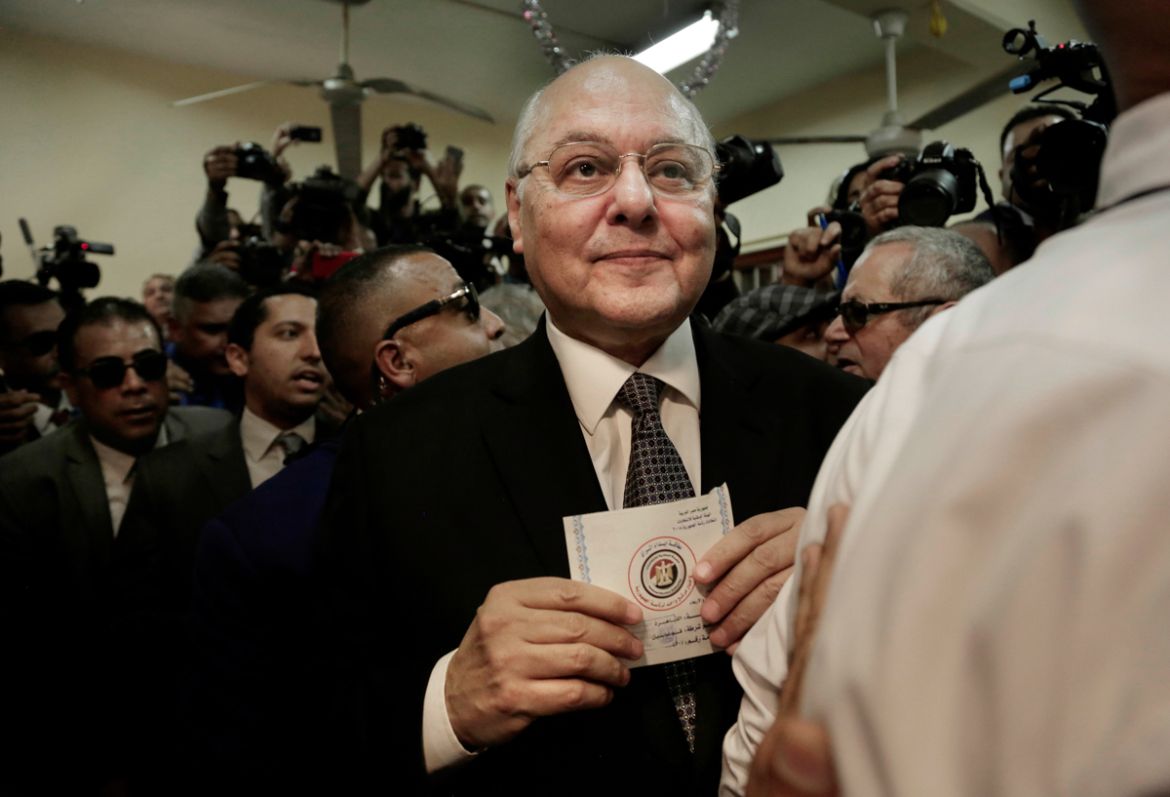 Egyptian presidential candidate Moussa Mustafa Moussa holds a ballot before casting his vote during the first day of the presidential election, at a polling station, in Cairo, Egypt, Monday, March 26,