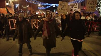 Maria Hamilton (centre), founder of Mothers for Justice, marches in memory of her son Dontre and others lost to vigilante and police violence. [Al Jazeera]