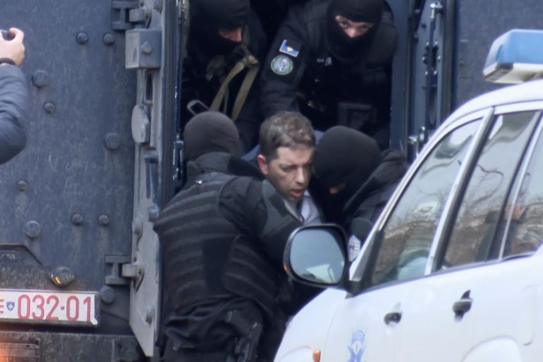 Djuric, head of the Serbian government office on Kosovo, is escorted out of a police vehicle in Pristina