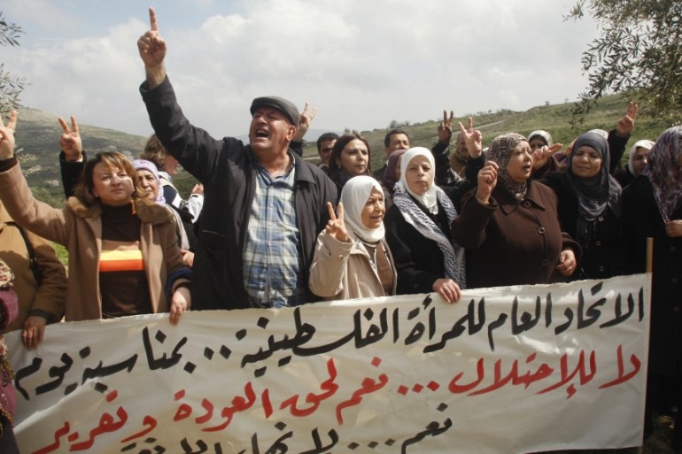 Palestinians gesture during a demonstration to mark International Women's Day in the West Bank village of Burin