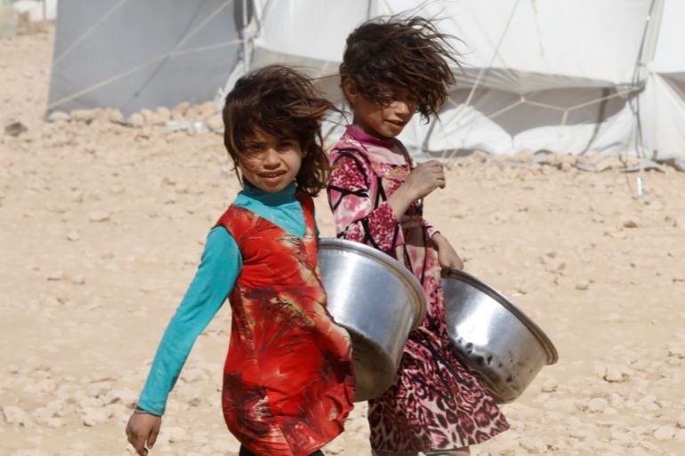 Girls carry containers for food rations at a refugee camp for people displaced by fightings between the Syrian Democratic Forces and Islamic State militants in Ain Issa