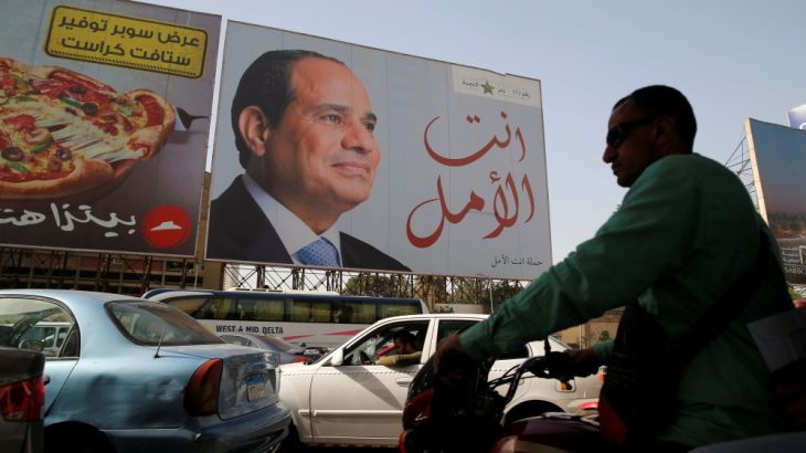 People walk in front of banners with Egypt''s President Abdel Fattah al-Sisi during preparations for the presidential election in Cairo