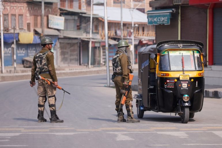 Indian police officer stop an auto-rickshaw after Kashmiri separatists called for a day-long strike against the recent killings in Kashmir, in downtown Srinagar