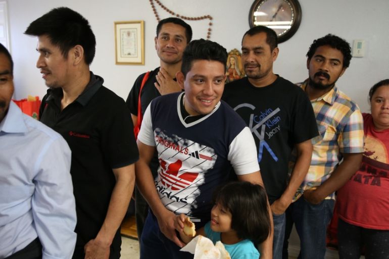 Undocumented immigrants recently released from detention through "catch and release" immigration policy wait in line for a pizza dinner at the Catholic Charities relief center in McAllen
