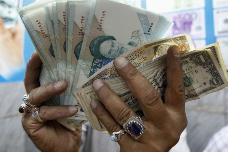 A vendor inspects Iranian rials at a currency exchange shop in Baghdad