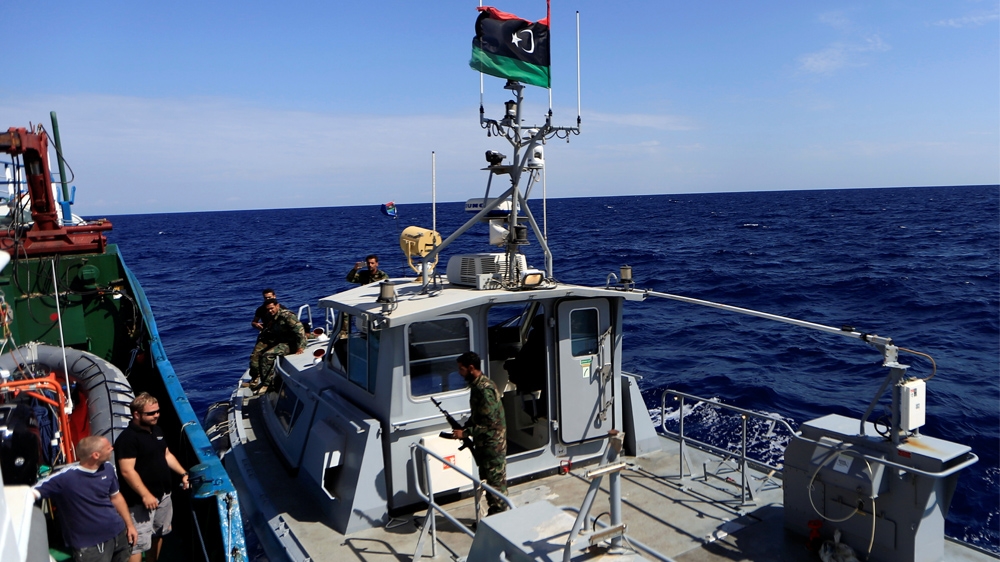 Members of the Libyan coastguard are seen on their boat after they approached and boarded German NGO Jugend Rettet's ship Iuventa during a patrol in September 2016 [Zohra Bensemra/Reuters] 