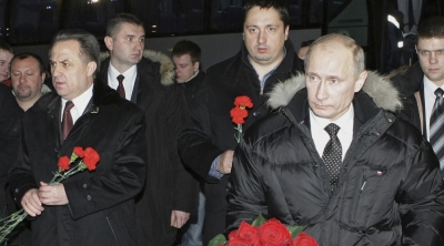 Alexander Shprygin (middle) walks with then-Russian Prime Minister Vladimir Putin and Sports Minister Vitaly Mutko (left) to lay flowers on the grave of a football fan who was killed in clashes after a football match in Moscow in December, 2010 [AP via RIA Novosti /Alexei Nikolsky]