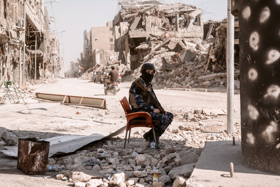 A local police officer sits at a checkpoint inside the old city. Since there are almost no one living the the area, the local police made several checkpoints to make sure no members of Daesh try to ma