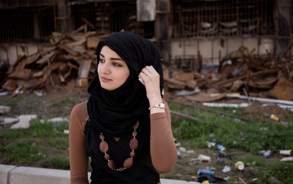 Hiba, 21 sits by the destroyed library of Mosul University. She studies to be an Arabic teacher although hopes one day she can pursue her dream of being a singer in the UK.