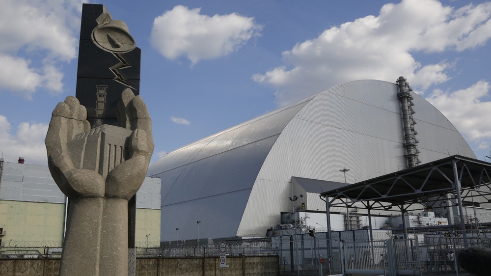 A monument pays homage to the builders who constructed the first sarcophagus over the Unit 4 reactor, which was replaced in 2016 [Efrem Lukatsky/AP Photo] 