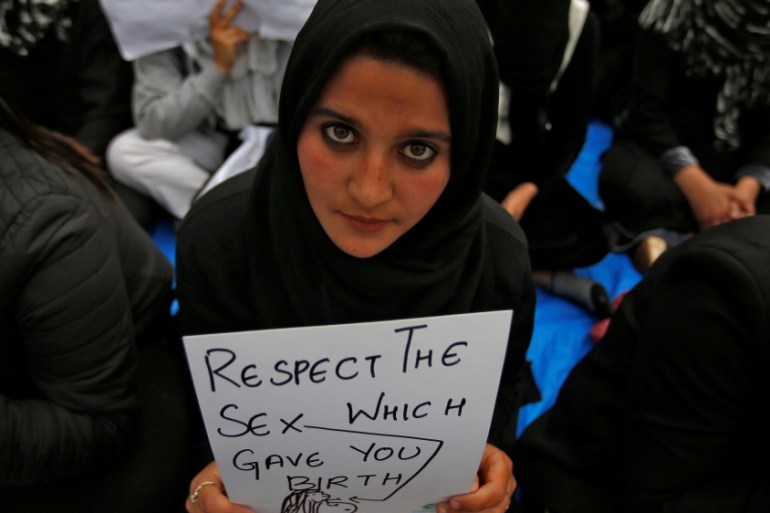 A student holds a placard as she participates in a signature campaign to protest against the rape of an eight-year-old girl in Kathua, near Jammu, in Srinagar