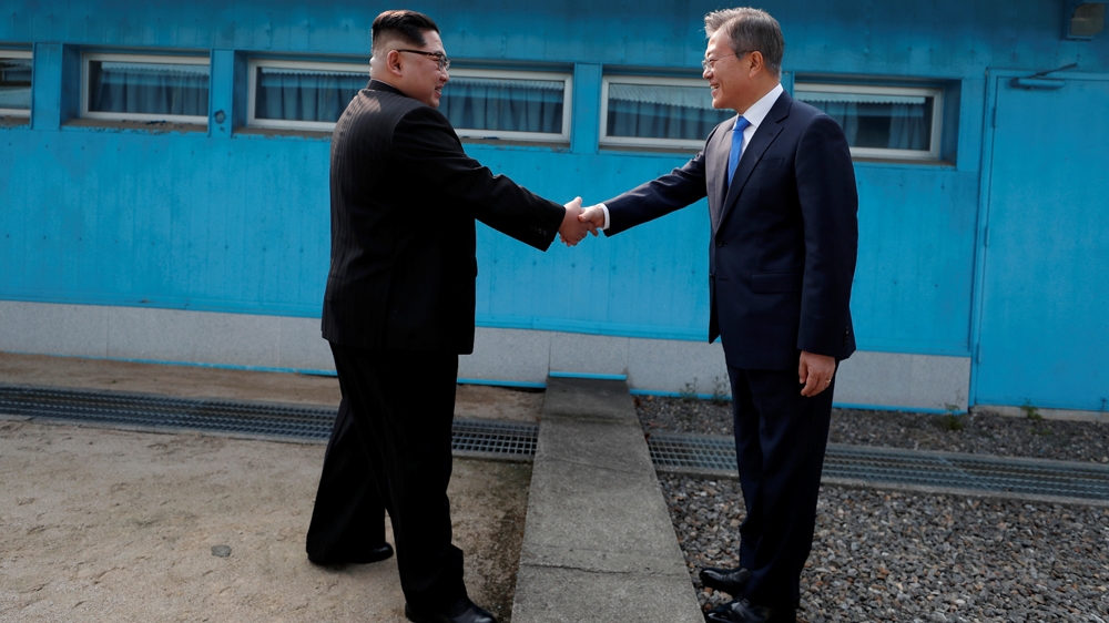 South Korean President Moon Jae-in shakes hands with North Korean leader Kim Jong-un as they meet at the military demarcation line separating the two countries [Korea Summit Press Pool via Reuters]